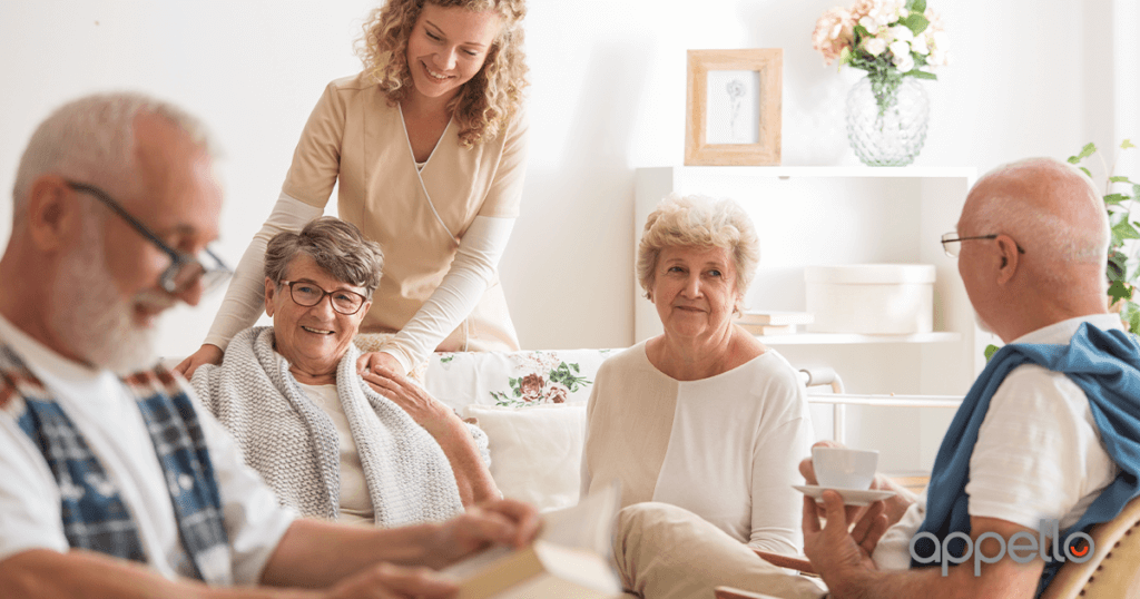 4 elderly people sat together having a coffee