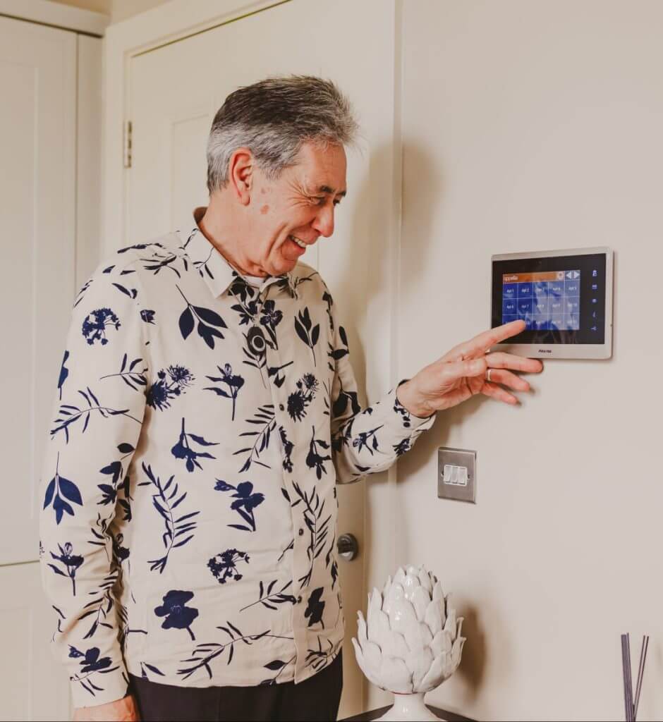Elderly man using warden call system, Smart Living Solutions in Corridor