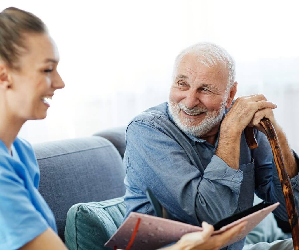 Old man with walking stick, talking to the carer