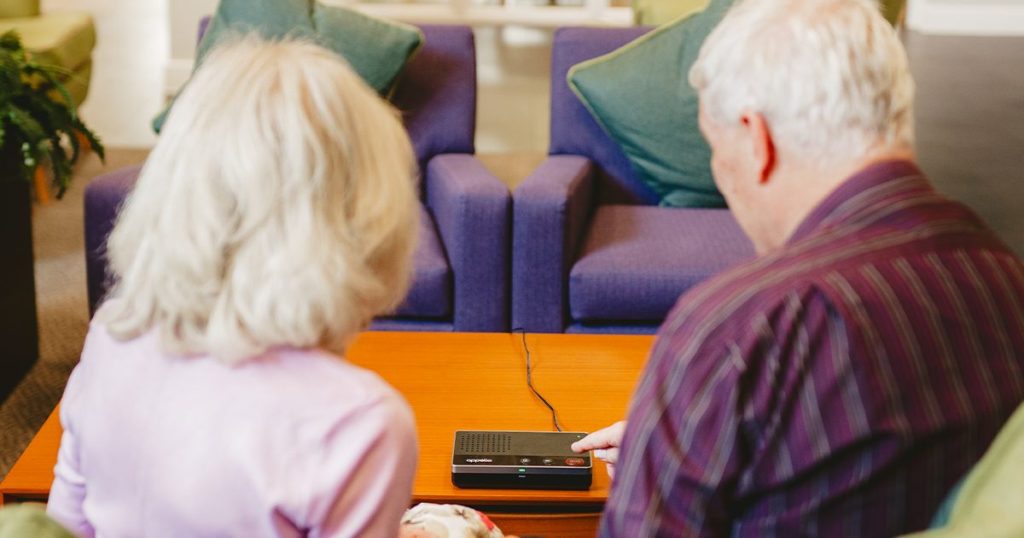Two elderly people about to press their emergency alarm